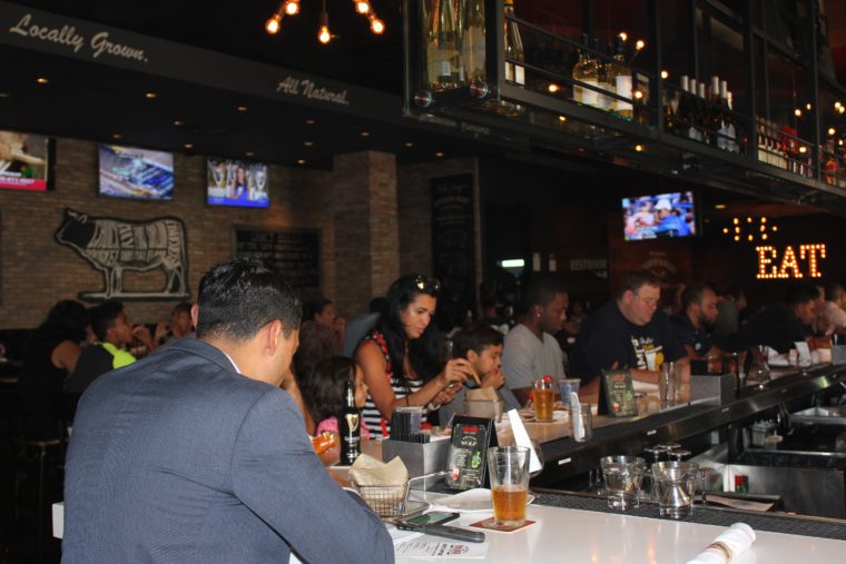 Pokemon GO Pop Up Party attendees sit around the bar at Gulfstream Park playing the game.