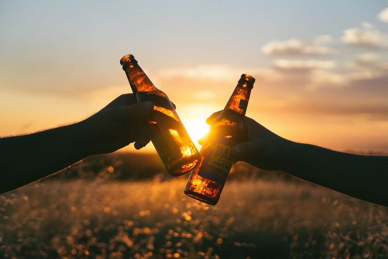 two people toasting beers