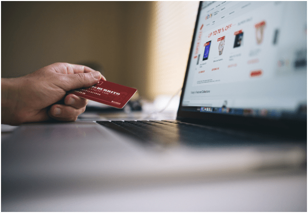 Shopper holding credit card while browsing through an online shopping site