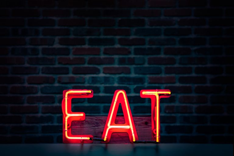 A neon sign with the letters E-A-T