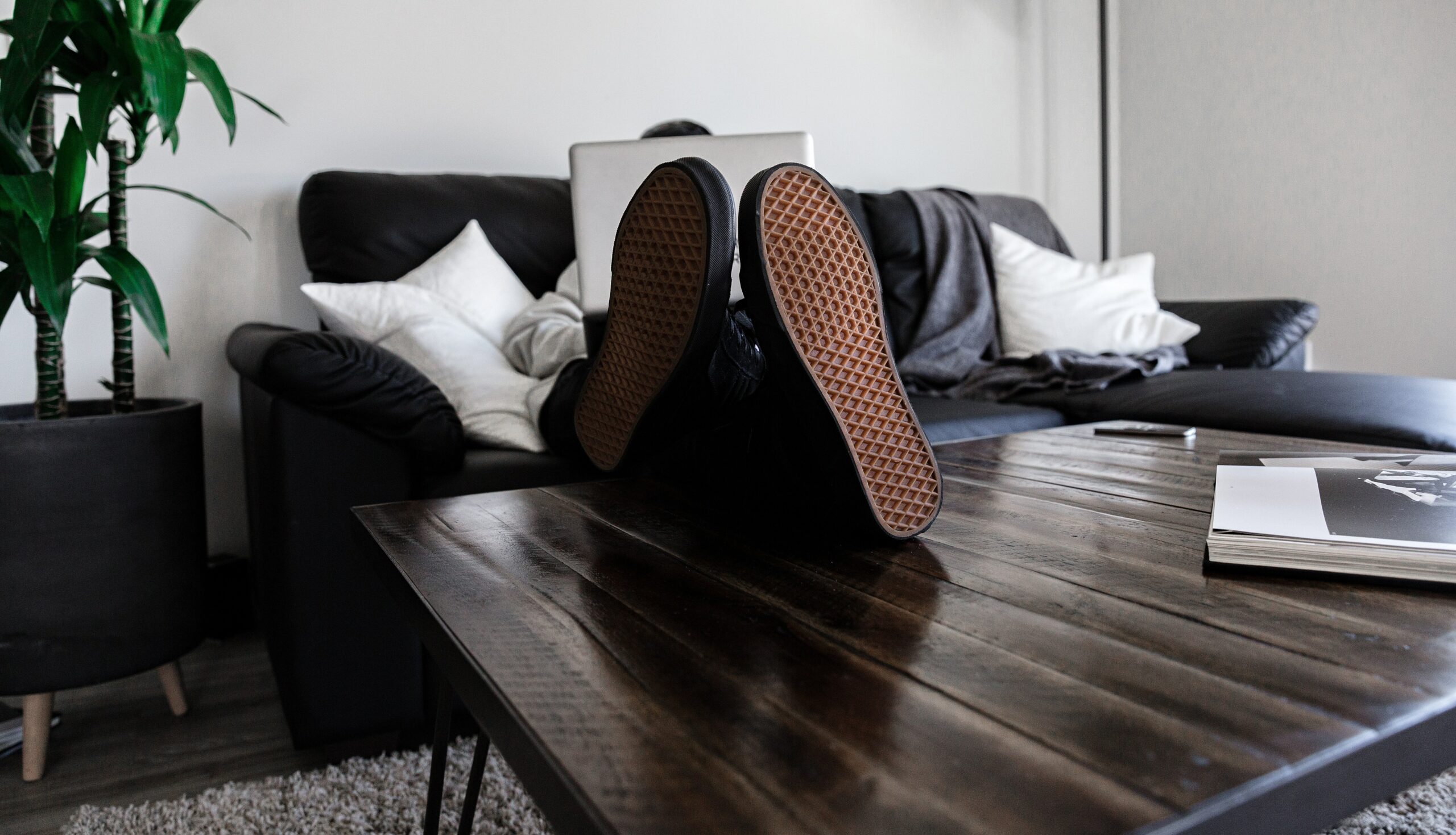 Man working on sofa with his feet on the table