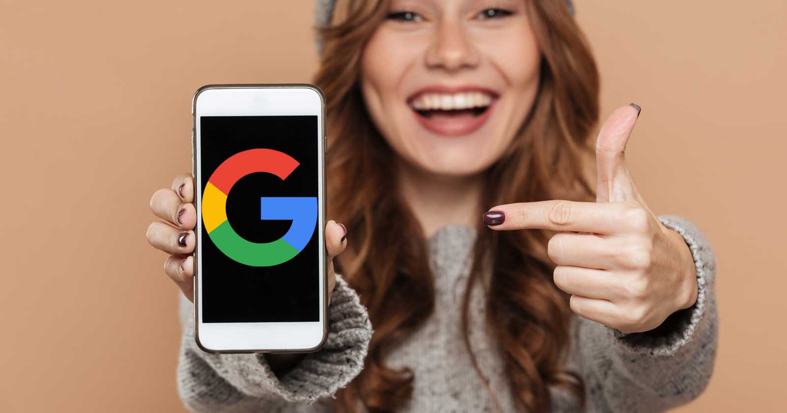Image of a woman holding a phone that displays Google's logo