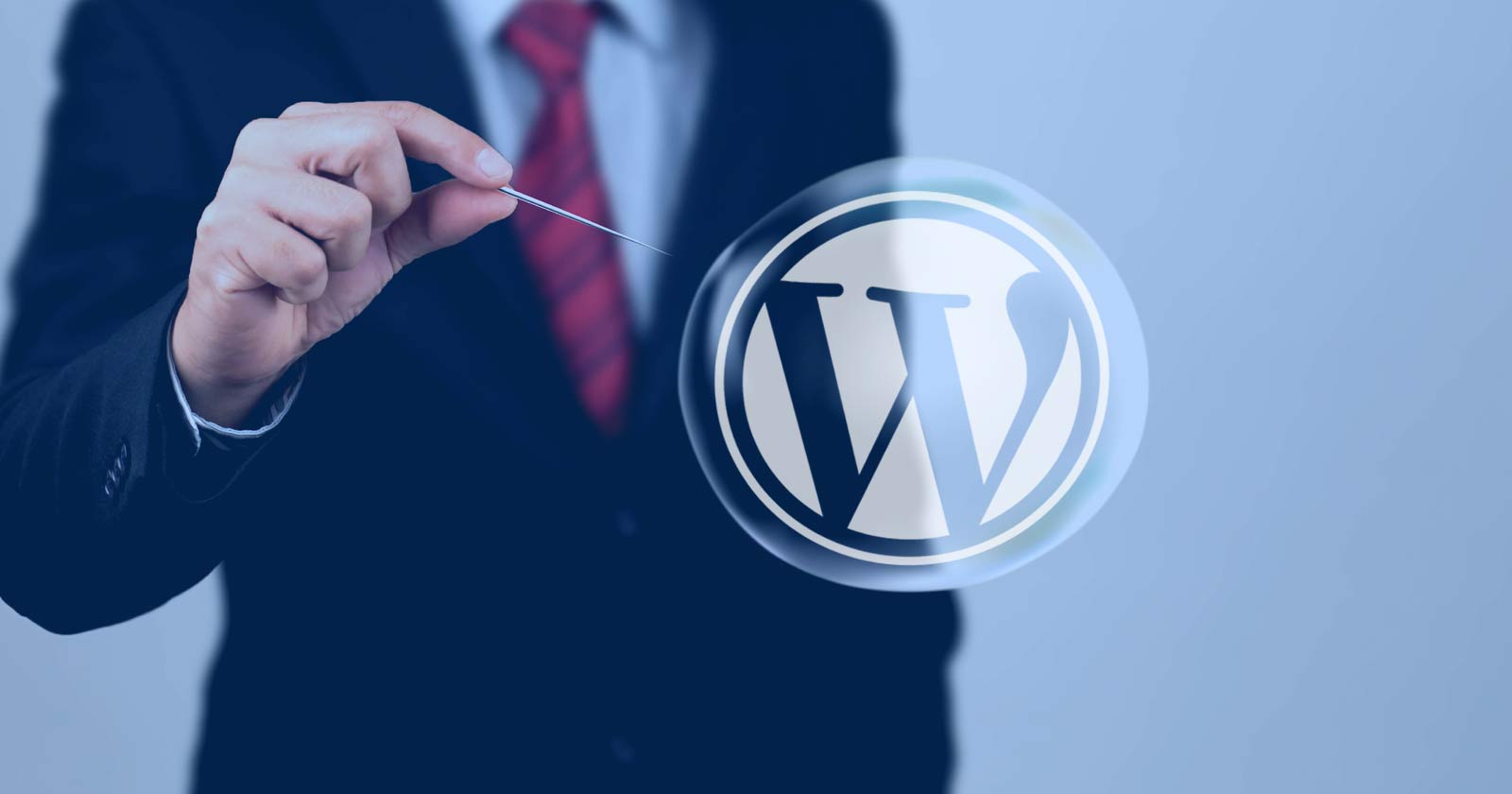 wordpress logo in a bubble with a pin about to pop it
