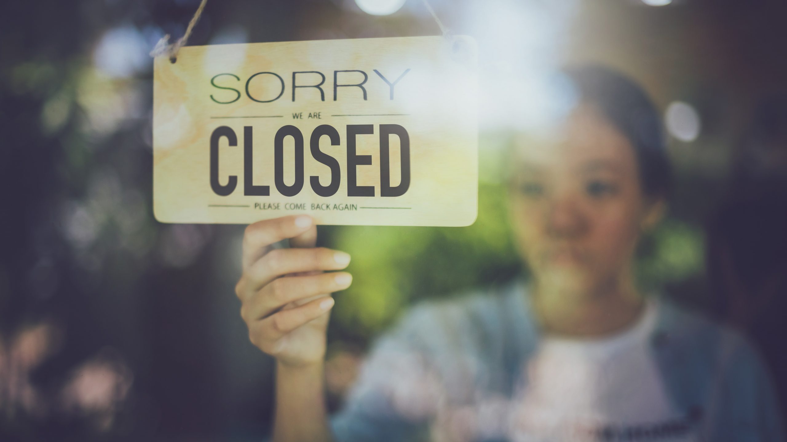 Woman hanging a closed sign