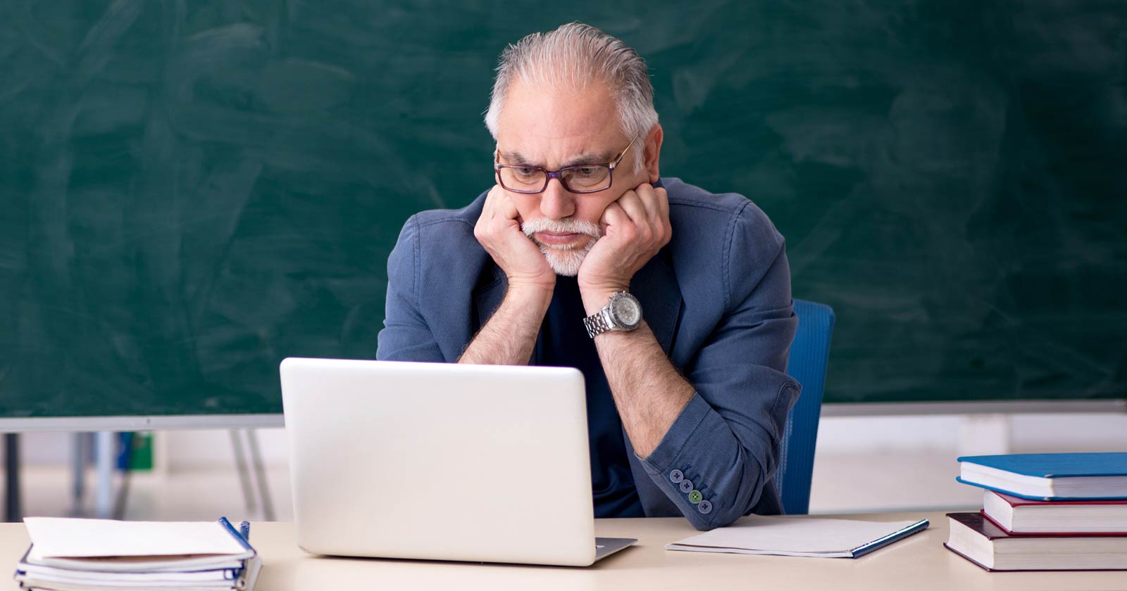 Image of an Educator staring into a laptop with concern