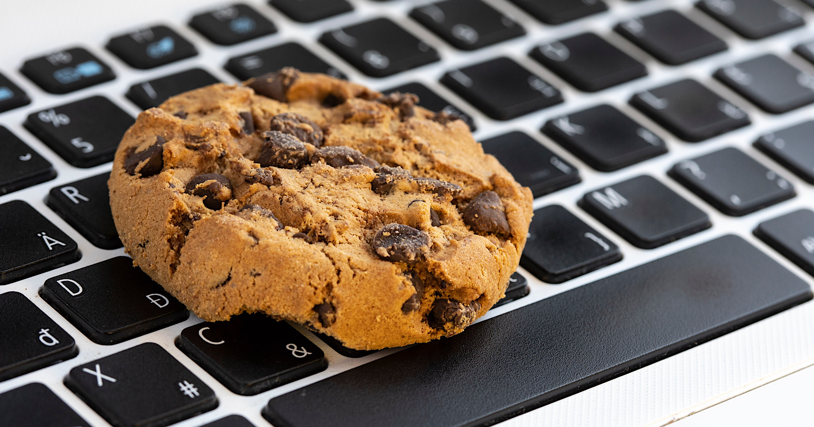 Chocolate cake cookie on keyboard symbol of internet cookies