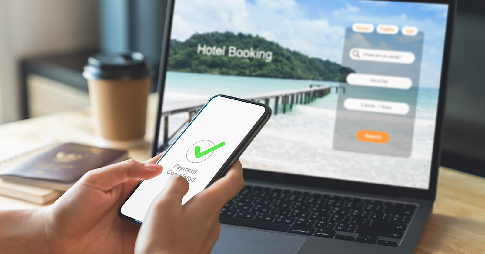 Hand using laptop and booking hotel on website for vacation after a long work and payment completed message on mobile, Summer holiday concept.